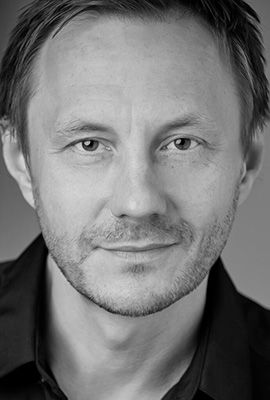 Das Portrait zeigt Shania Ochsner mit langen, zusammen gebunden blonden Haaren. Sie trägt ein weiß gesticktes Oberteil und eine dezente Halskette mit silbernem Herzanhänger.