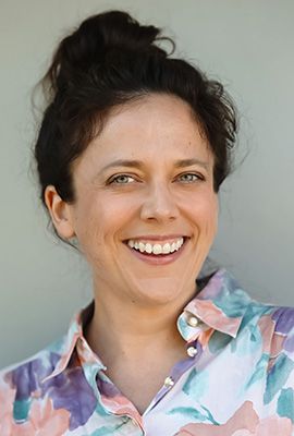 Das Portrait zeigt Amanda Mitrevski mit mittellangen, schwarzen Haaren und einem dezenten Lächeln.